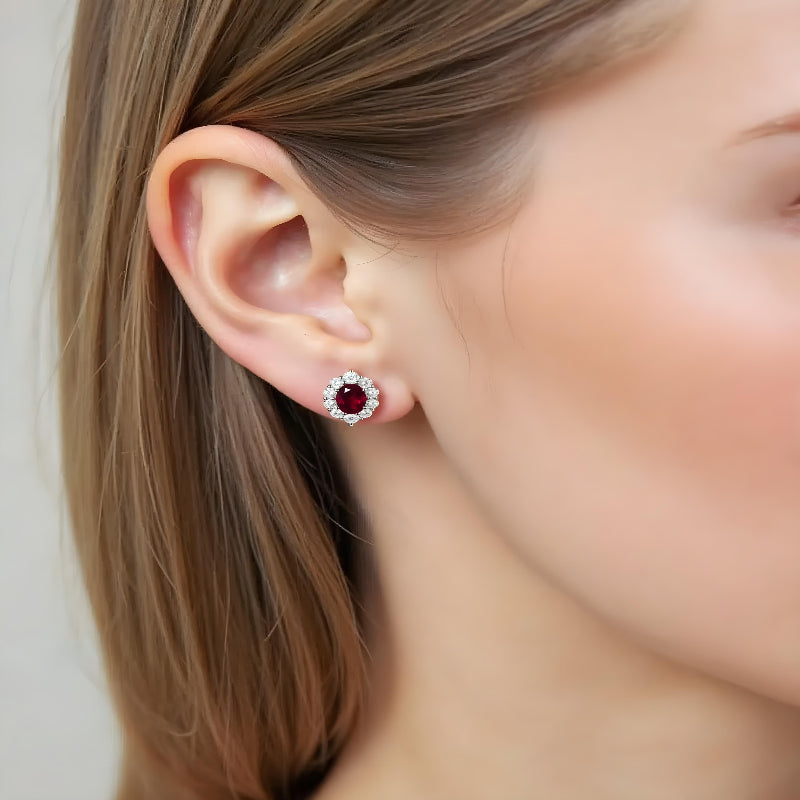 Woman wearing 2 carat ruby and diamond halo stud earrings – elegant gemstone jewellery by Aeterna Jewellery UK