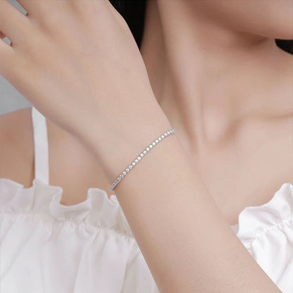 Elegant woman styling Aeterna Jewelry silver tennis bracelet with white dress