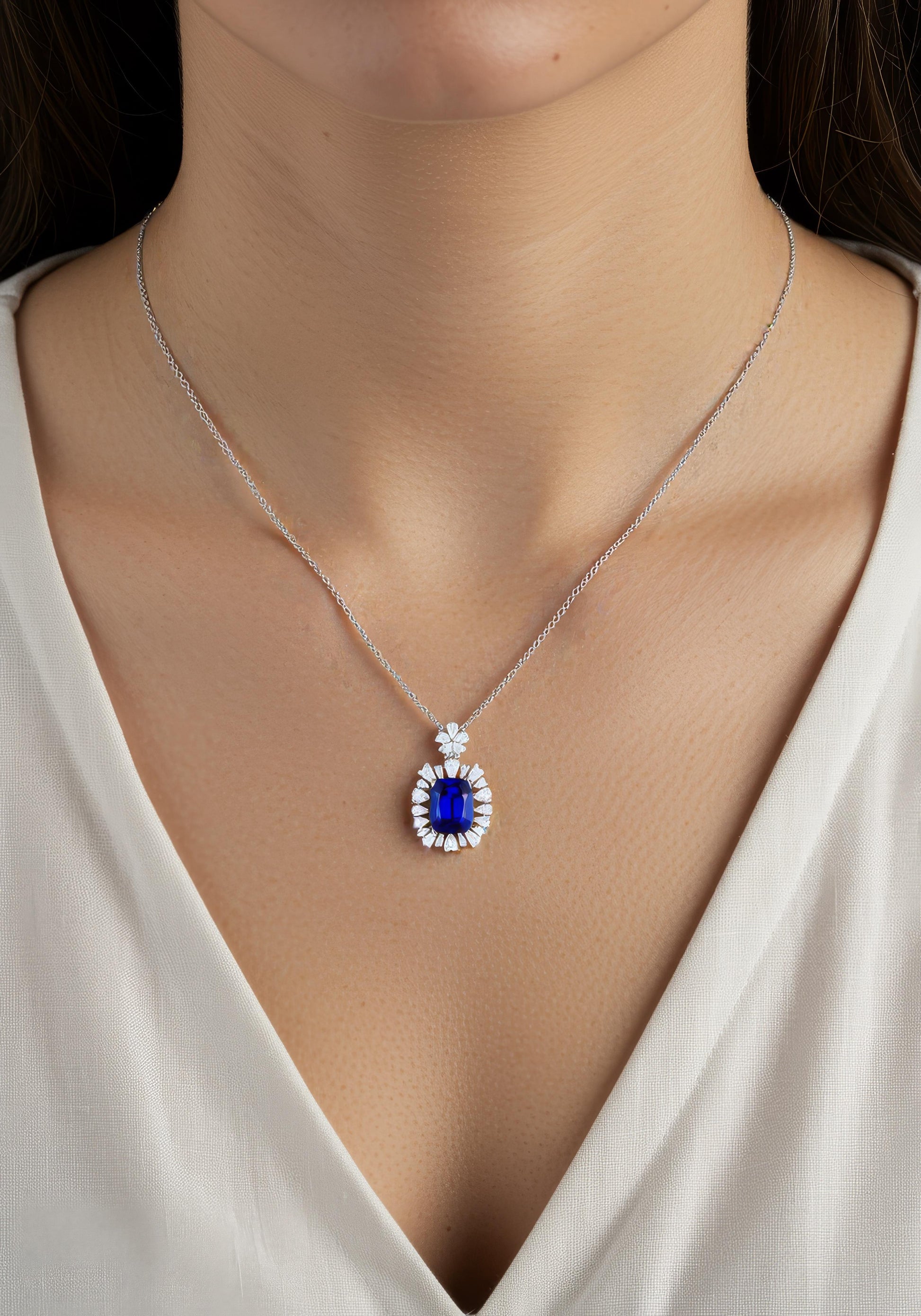 Elegant sapphire pendant surrounded by diamonds, silver chain close-up