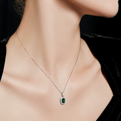 Aeterna Jewelry emerald halo pendant necklace worn on model’s neckline
