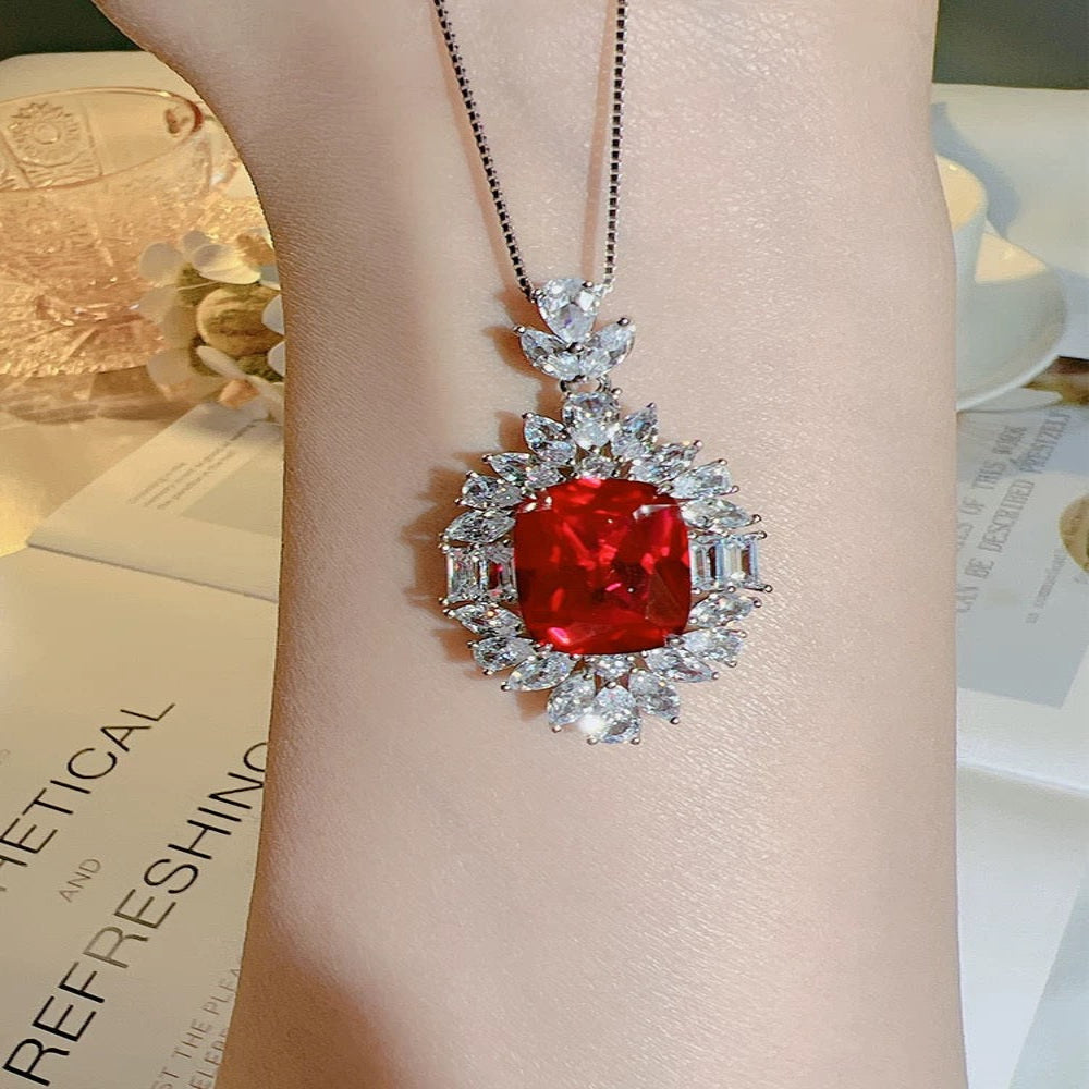 Aeterna Jewelry red ruby halo pendant shown resting on wrist in lifestyle scene