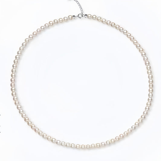 Freshwater pearl necklace with adjustable silver chain, full circle layout showing lustrous white pearls, Aeterna Jewelry minimalist design